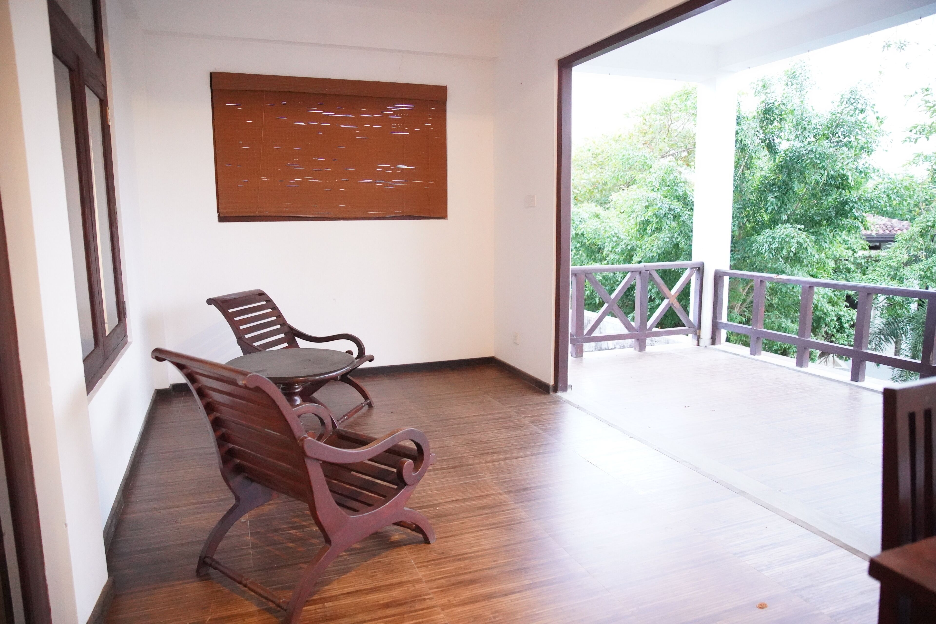 Ein Balkon mit Holzboden und einem Tisch mit zwei Stühlen.