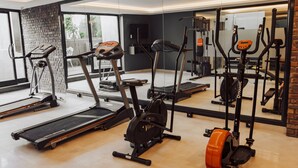 Un gimnasio con cintas de correr, elíptica y bicicleta estática.