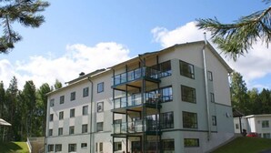 A multi-story hotel with a modern architectural design, featuring balconies and large windows.