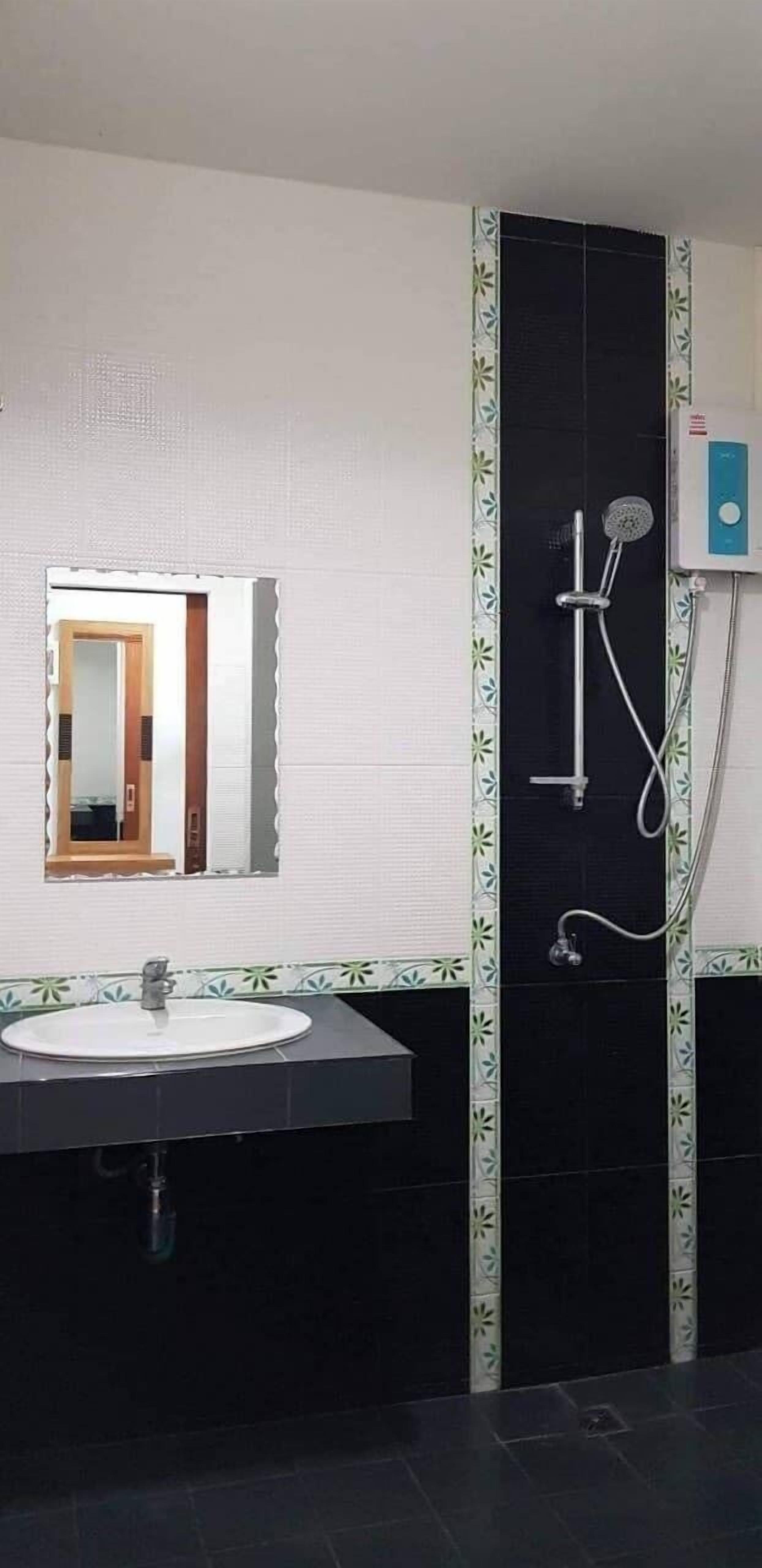 Een badkamer met een wastafel, spiegel en douche.