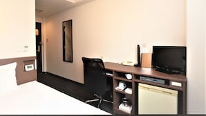 A hotel room with a bed, a desk with a computer, a chair, a television, and a coffee maker. - Smile Hotel Mito (Mito)