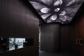 Een modern interieur met een uniek plafondontwerp, een receptiegedeelte en een gebogen muur.