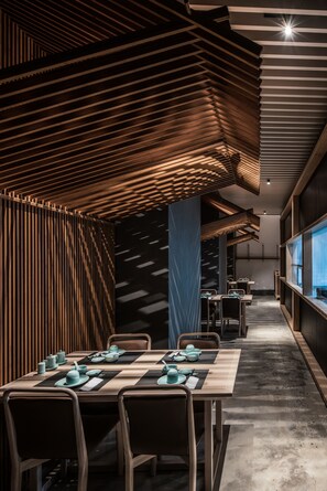 A modern restaurant interior with wooden slatted ceilings, long tables, and chairs. - The Nook Hotel Hangzhou (Hangzhou)