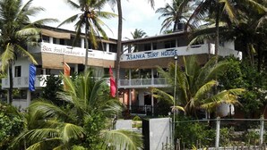 Un edificio con un letrero que indica 'Sea Food Restaurant & 100ms' y 'Asanka Surf House'.