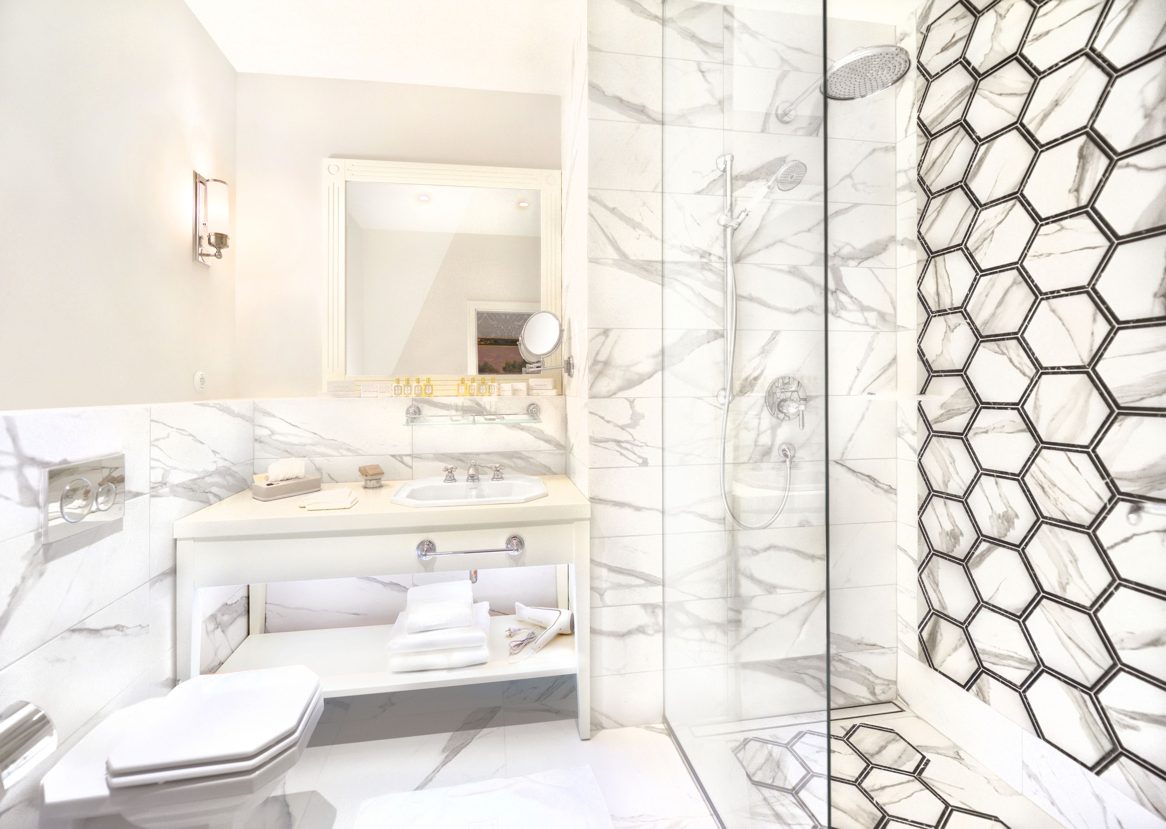 A modern bathroom with a marble sink, a glass shower enclosure, and a hexagonal tile backsplash.
