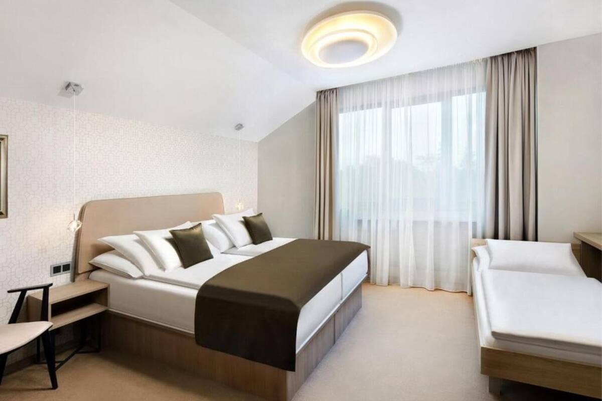 Een hotelkamer met een groot bed, een bureau en een stoel.