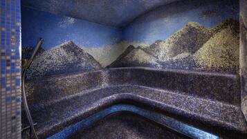 A room with a mosaic wall depicting a mountainous landscape.