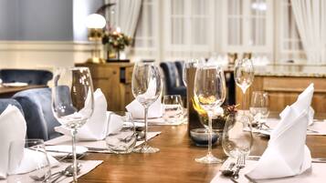 A dining table set with multiple wine glasses, plates, and cutlery, indicating a formal dining arrangement.