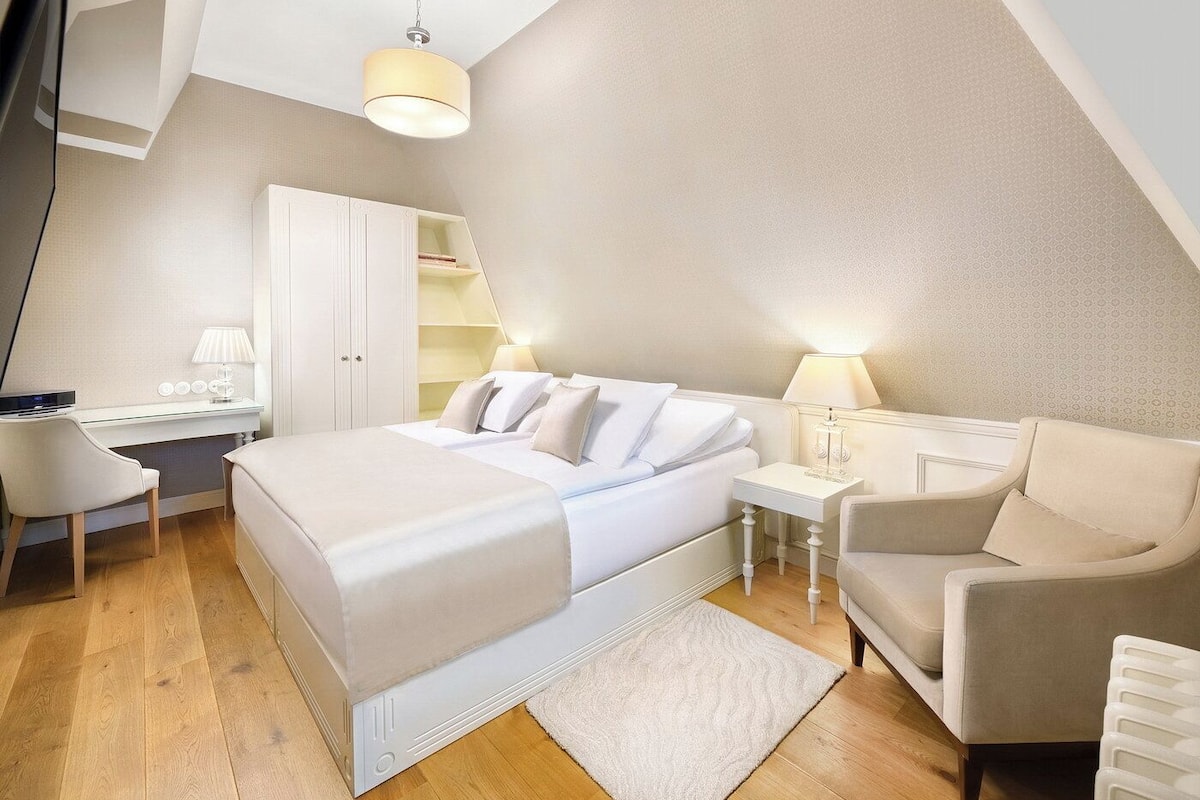 Een moderne slaapkamer met een bed, bureau, stoel en kledingkast.