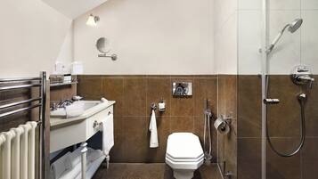 A compact bathroom with a toilet, sink, and shower.