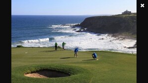 A golf course with a view of the ocean and a cliff. - Pinnacle Point Pool Lodge (Mossel Bay)