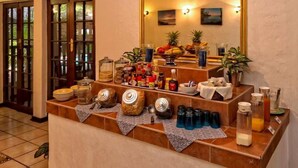 A buffet setup with various food items, condiments, and beverages. - La Mer Lodge (Richards Bay)