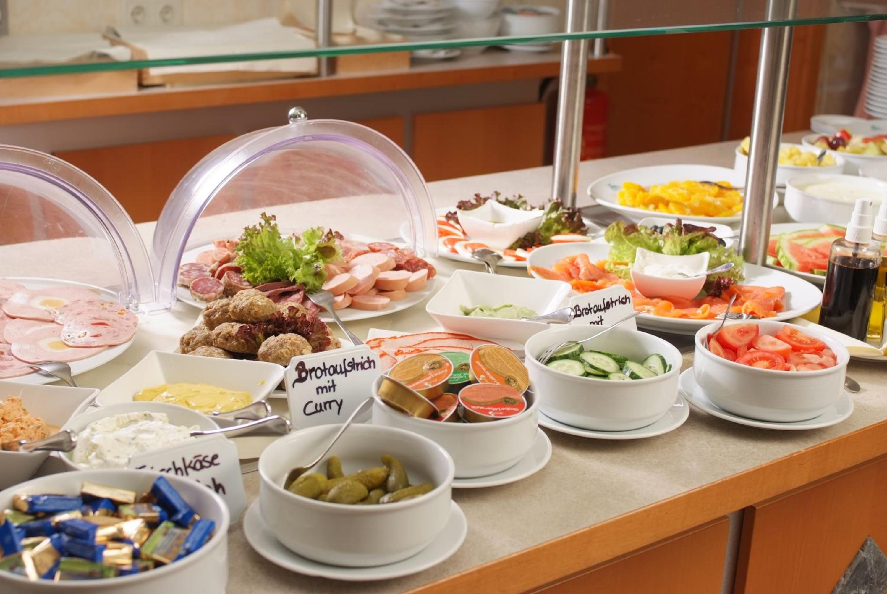 Un buffet proposant une variété de plats, notamment des viandes, des salades et des accompagnements.