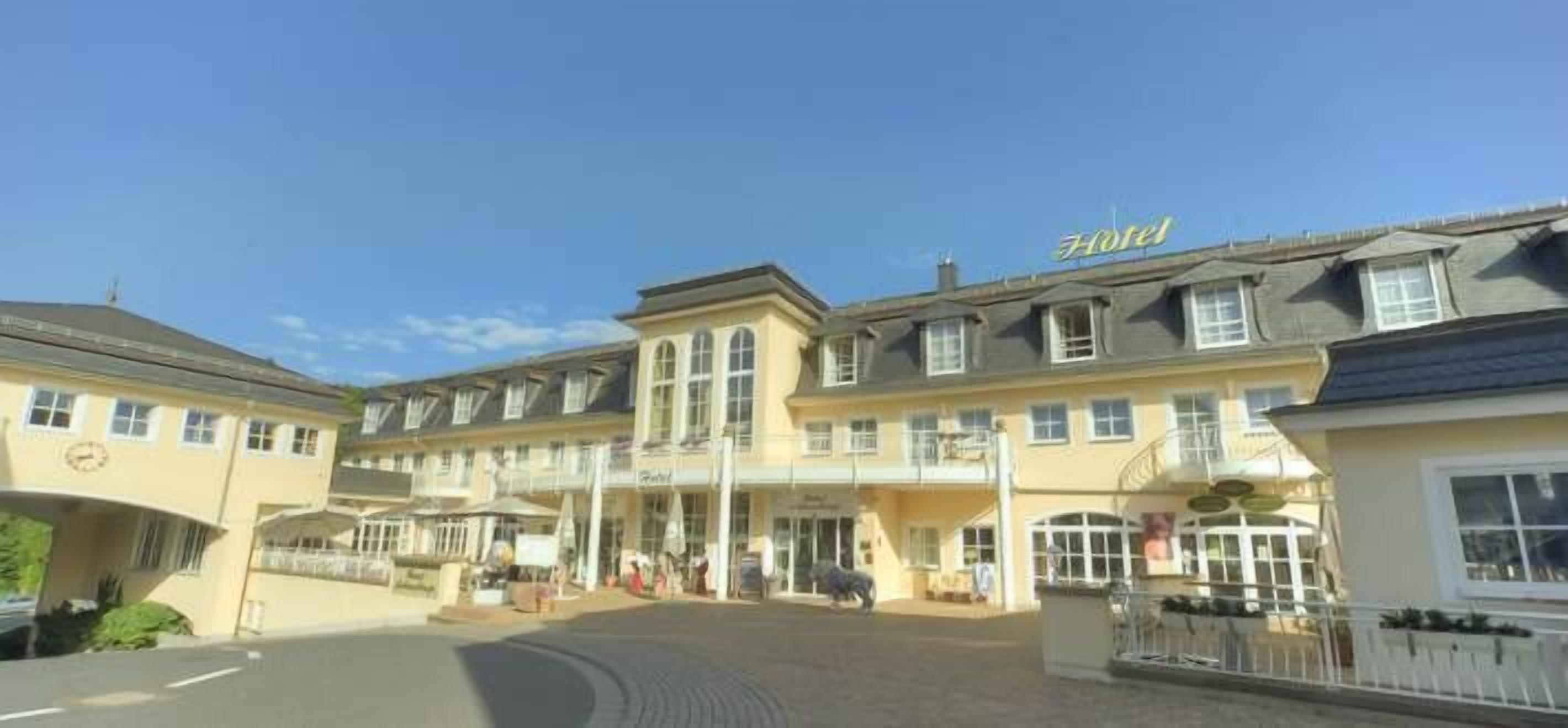 A hotel with a central entrance, multiple floors, and a sign indicating it is a hotel.