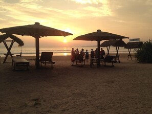 A beach scene with sun umbrellas and lounge chairs. - Aussie Swiss Beach Resort (Weligama)