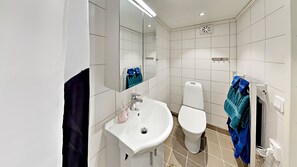 A modern bathroom with a white sink, a toilet, and a mirror. - Woodstock B&B & Studio Apartments (Balsta)