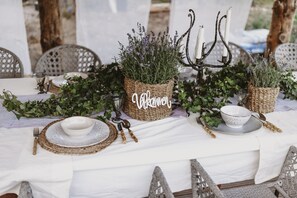 A table set with white tablecloth, woven baskets, and greenery. - Woodstock B&B & Studio Apartments (Balsta)