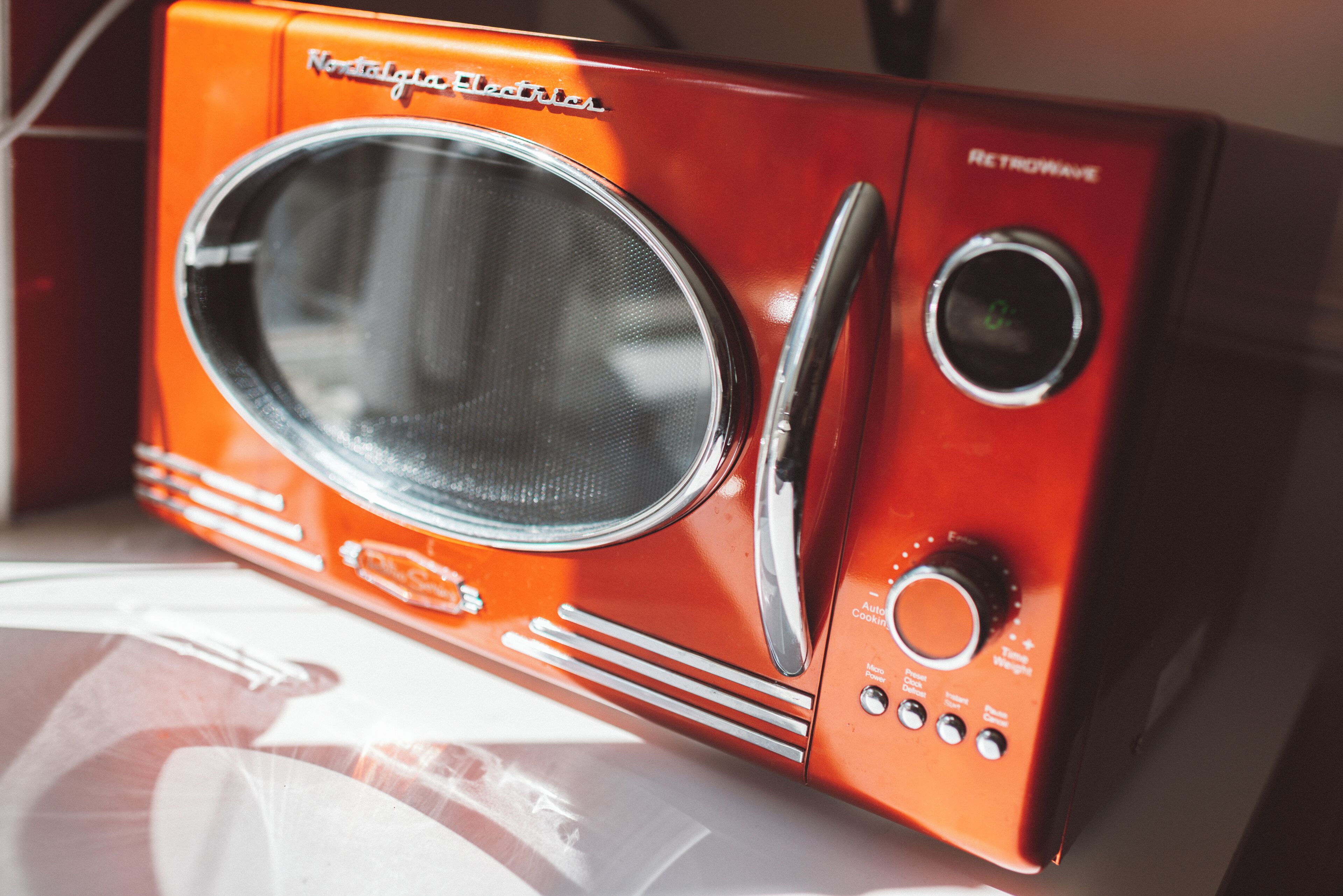 A retro-style microwave oven with a control panel, a dial, and a display.