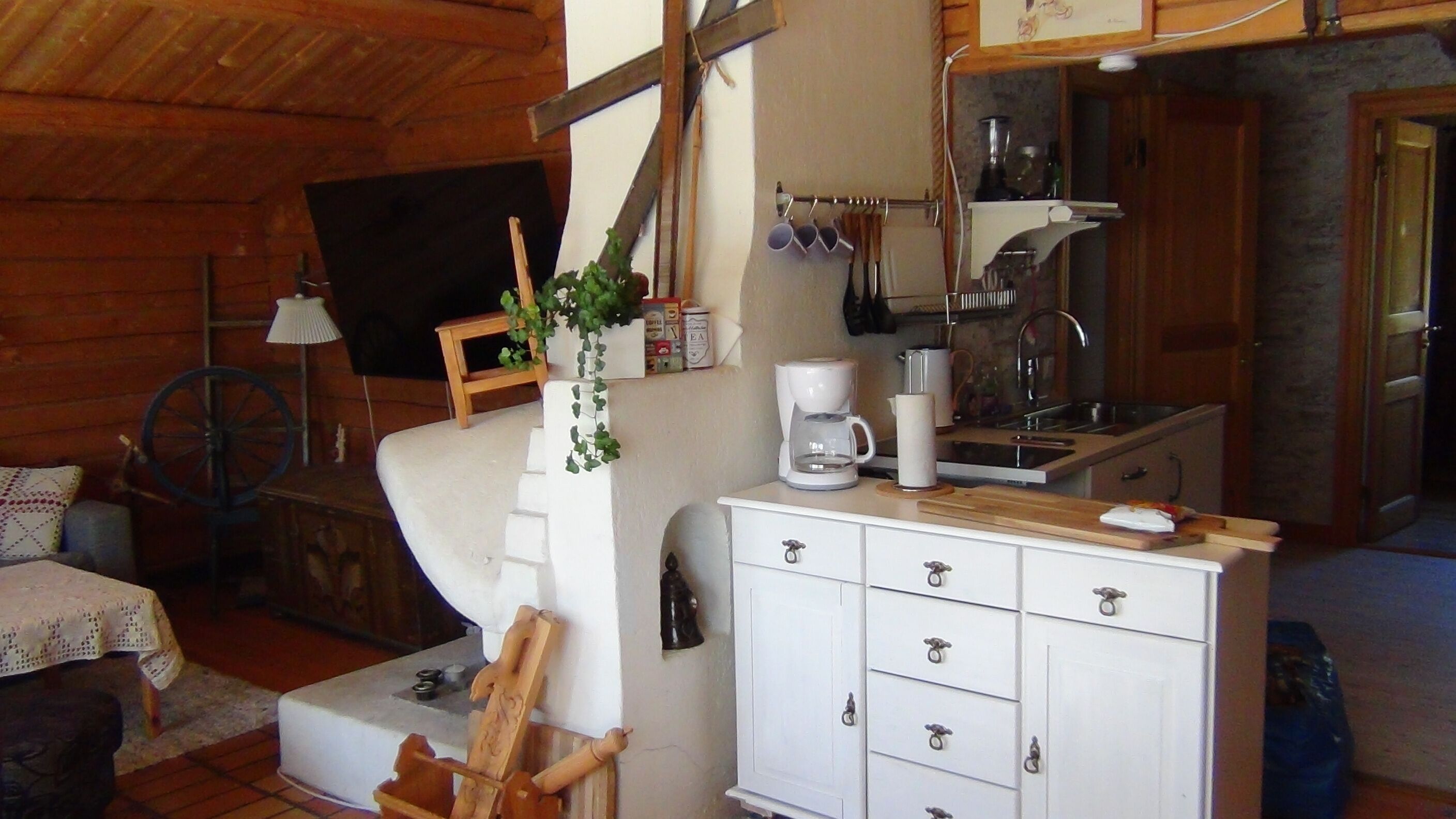 Una sala acogedora con un sofá, una mesa de centro y un pequeño armario de madera.