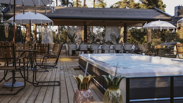 An outdoor patio with a hot tub, wooden deck, and outdoor seating area. - Woodstock B&B & Studio Apartments (Balsta)