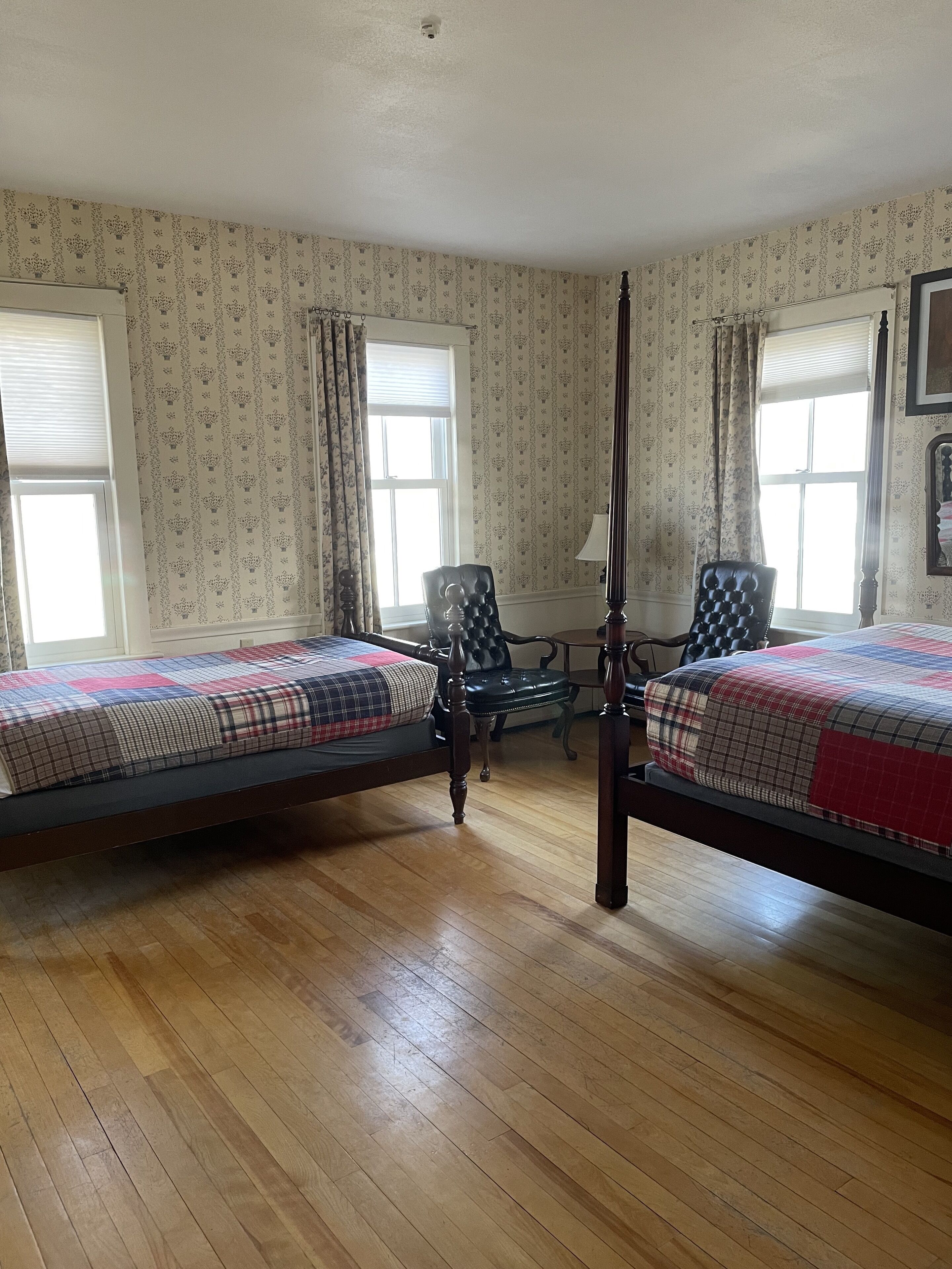 Ein Zimmer mit zwei Holzbett, einem Schreibtisch und einem Stuhl.