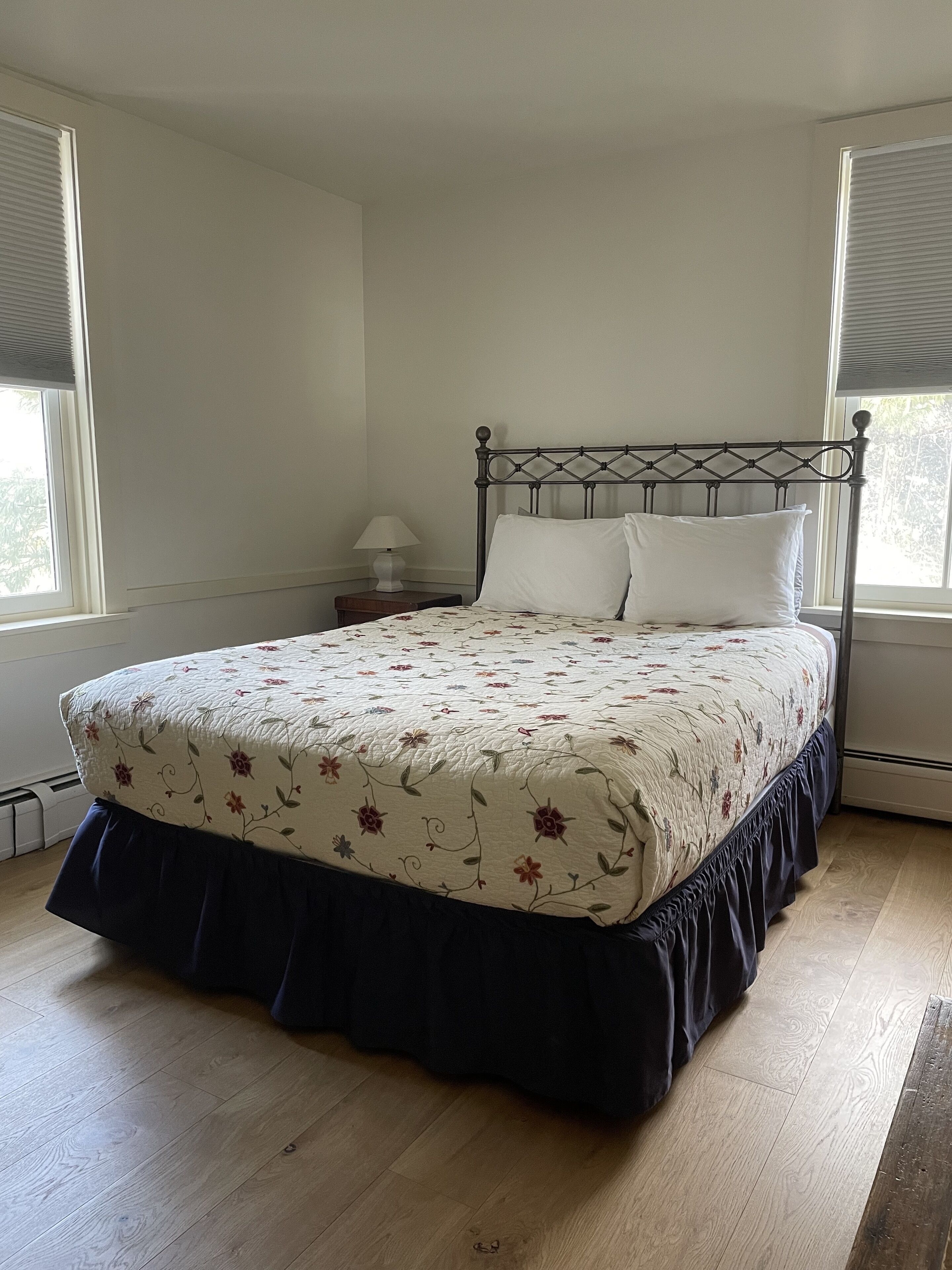 Una camera da letto con un letto, un comodino e una finestra.