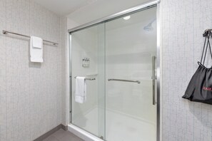 A modern bathroom with a glass shower enclosure, a towel rack, and a bag hanging on a hook. - Holiday Inn Express & Suites Moore by IHG (Moore)