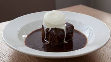 A dessert on a white plate with a scoop of ice cream on top.