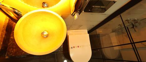 A bathroom with two yellow sinks, a toilet, and a shower.