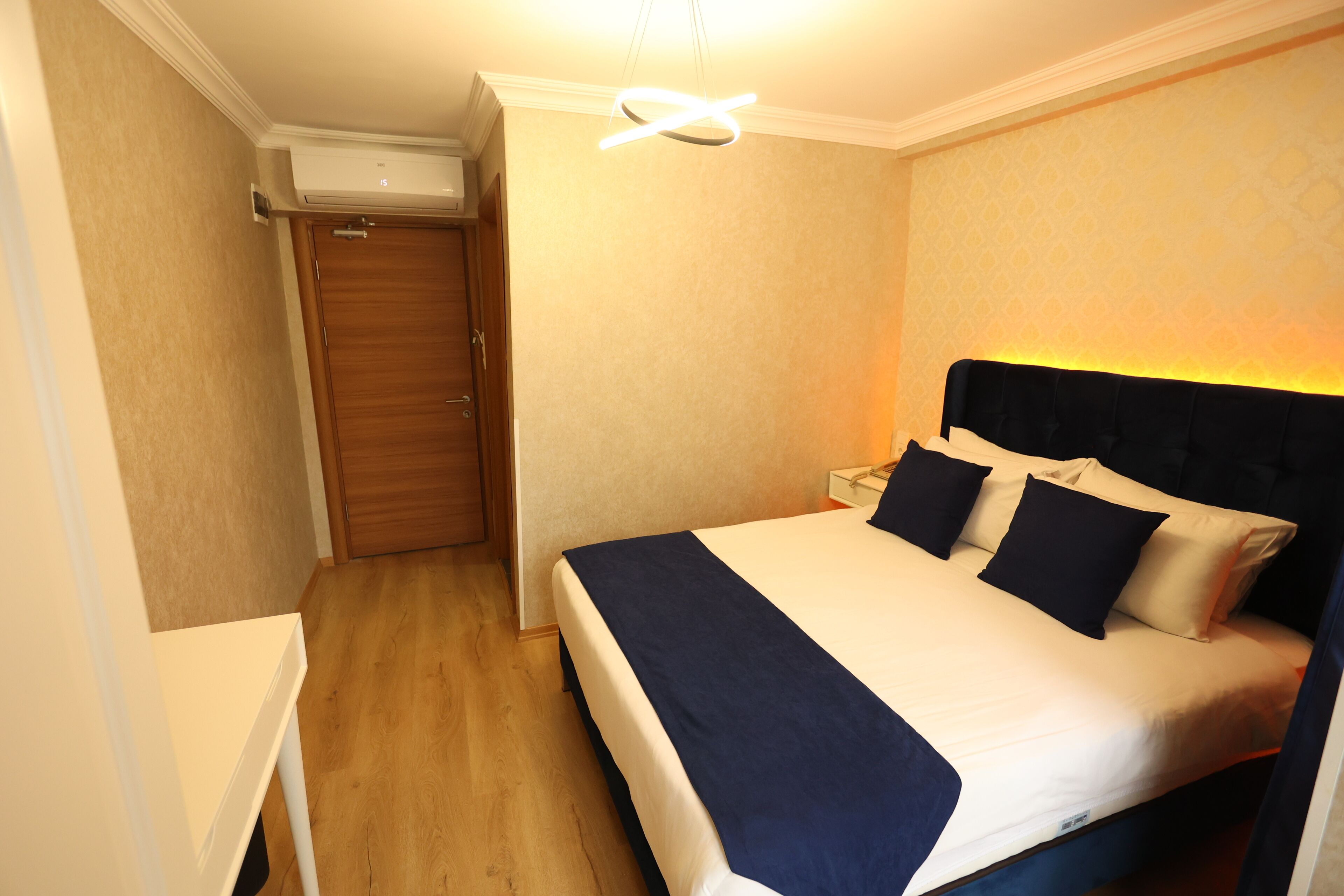 A neatly arranged bedroom with a bed, bedside tables, and a wardrobe.