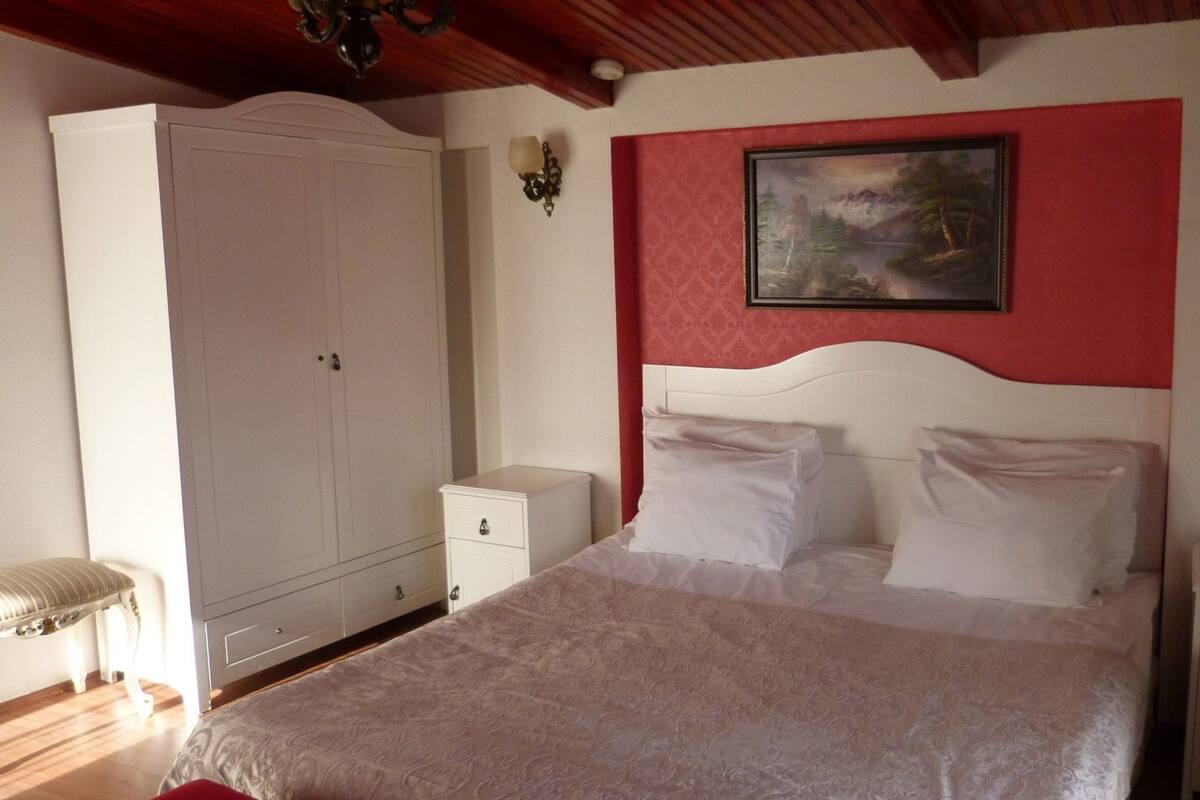 Ein Schlafzimmer mit Bett, Schrank, Nachttisch und einem Bild an der Wand.
