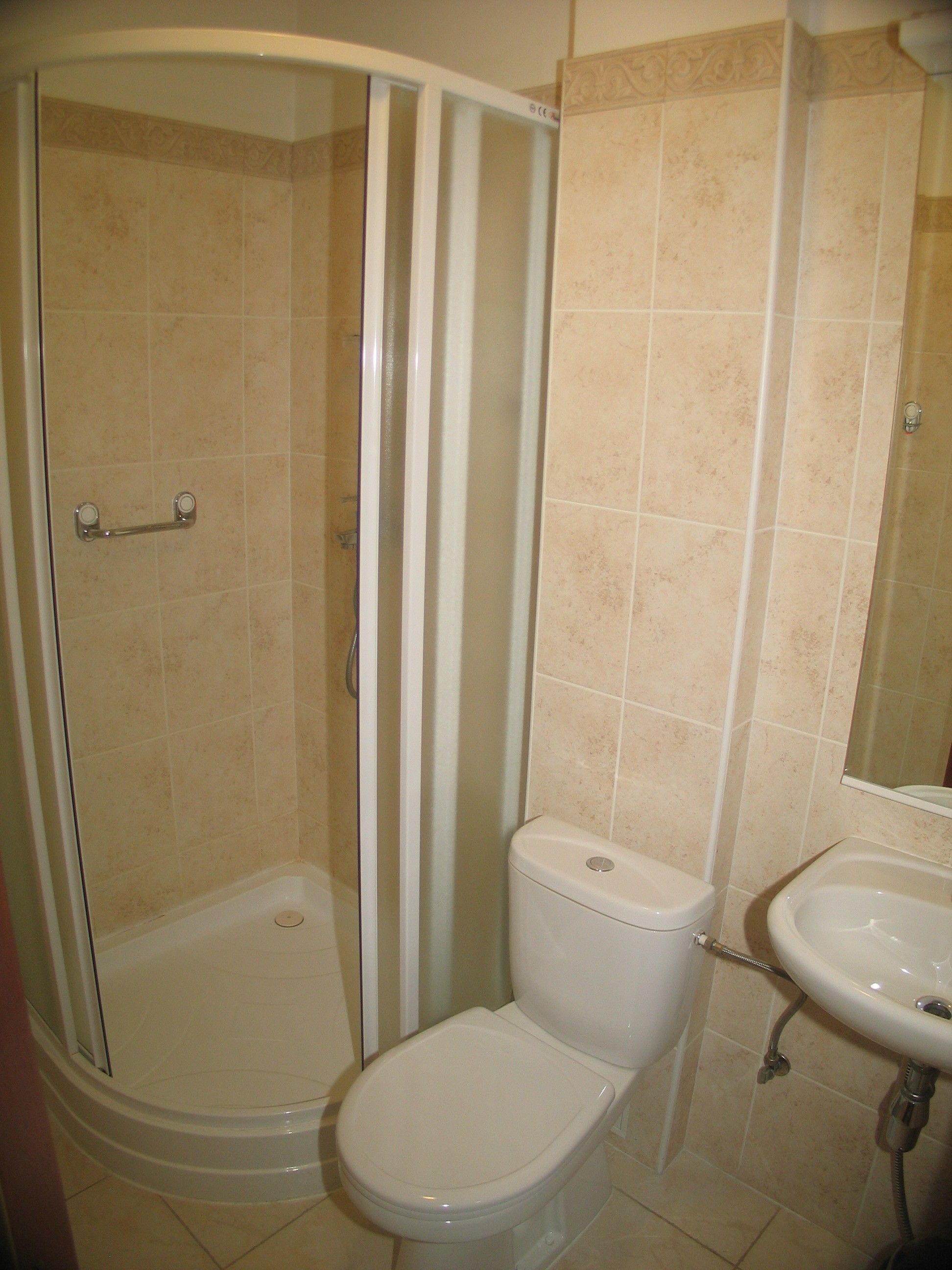 A bathroom with a shower, toilet, and sink.