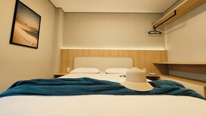 A hotel room with a bed, a nightstand, a wall-mounted shelf, and a painting. - Joaquina Beach Hotel (Florianópolis)