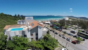 A building with a sign reading "Joaquina beach hotel" and a swimming pool.