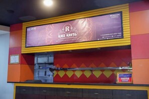 A restaurant with a large signboard, a counter, and a menu display. - Riez Palace Hotel (East Tegal)