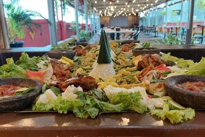 A buffet spread with various dishes and condiments. - Riez Palace Hotel (East Tegal)
