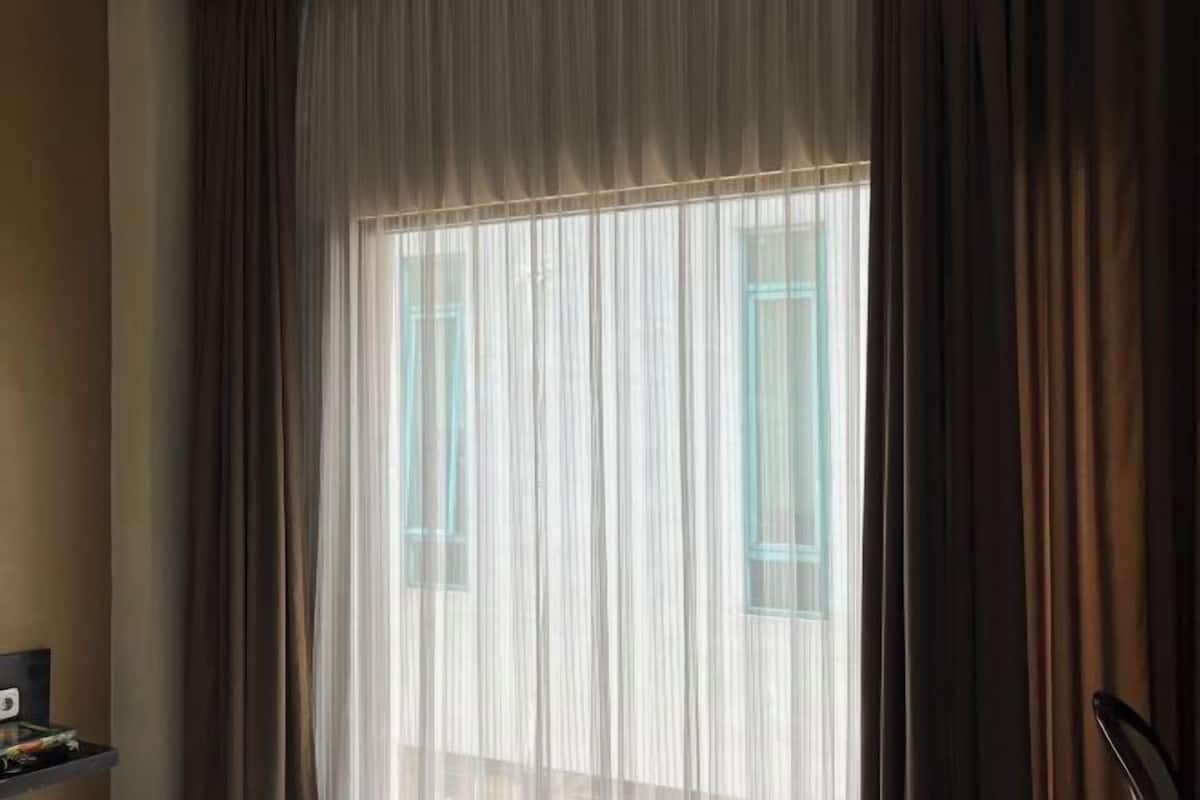 A room with a large window, a chair, and a small table.