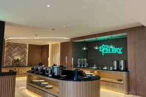 A modern hotel reception area with a curved counter, a neon sign, and a herringbone-patterned wall. - Riez Palace Hotel (East Tegal)