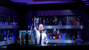 A bar area with shelves of liquor bottles and a bartender. - Grand Jambi (Jambi)