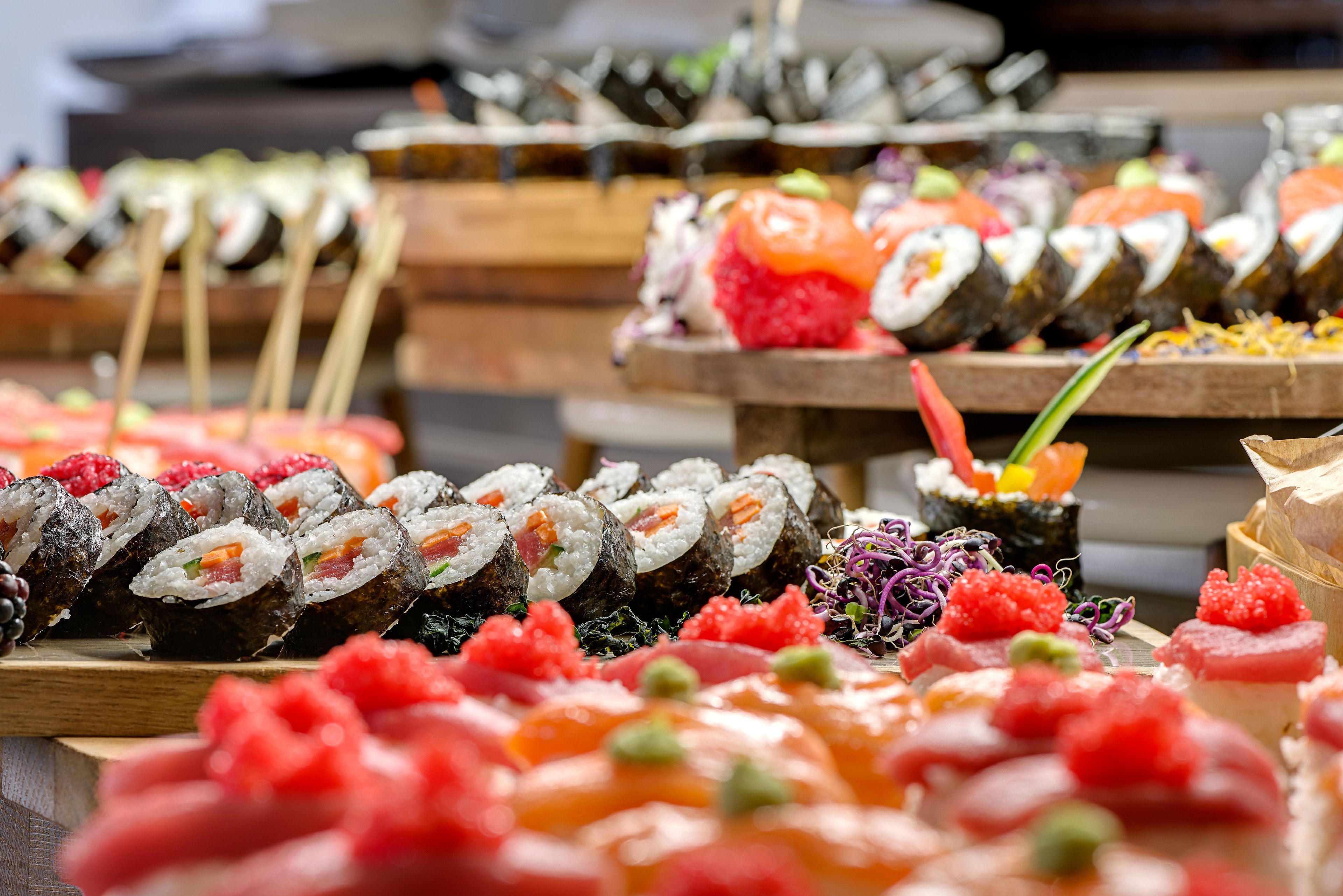 A variety of sushi displayed on wooden trays.