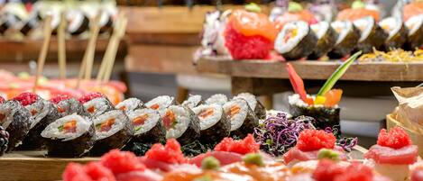 A variety of sushi displayed on wooden trays.