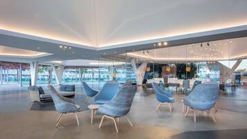 Un vestíbulo moderno con mobiliario contemporáneo, paredes de vidrio y un diseño espacioso.