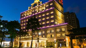 A multi-story hotel with illuminated signage and a well-lit entrance. - Royal Gold Hotel (Kaohsiung)