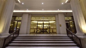 A grand entrance with marble columns, a staircase, and a glass door leading to a lobby area. - Royal Gold Hotel (Kaohsiung)