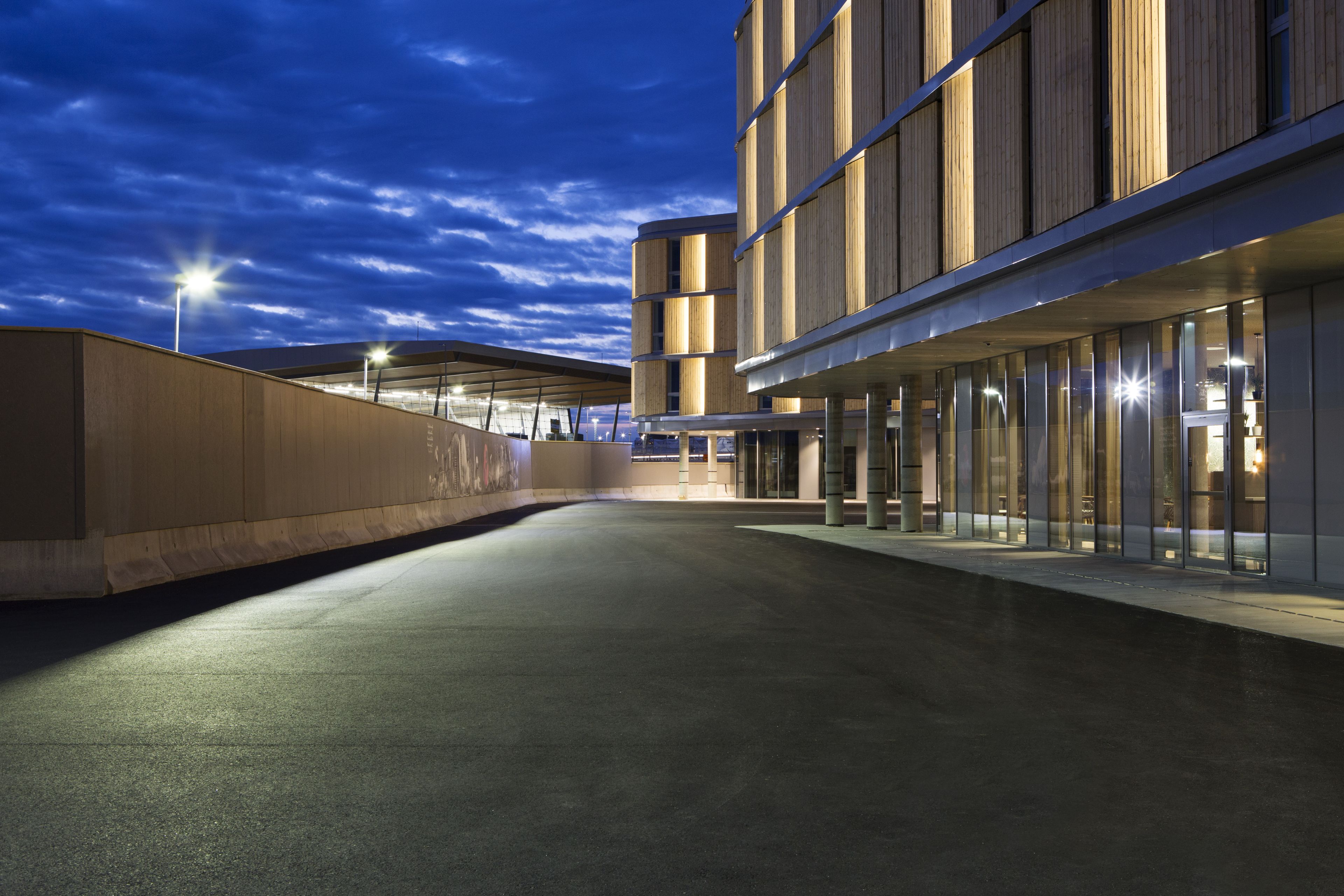 Un edificio moderno con fachada curva y grandes ventanales, probablemente un hotel o un complejo de oficinas.