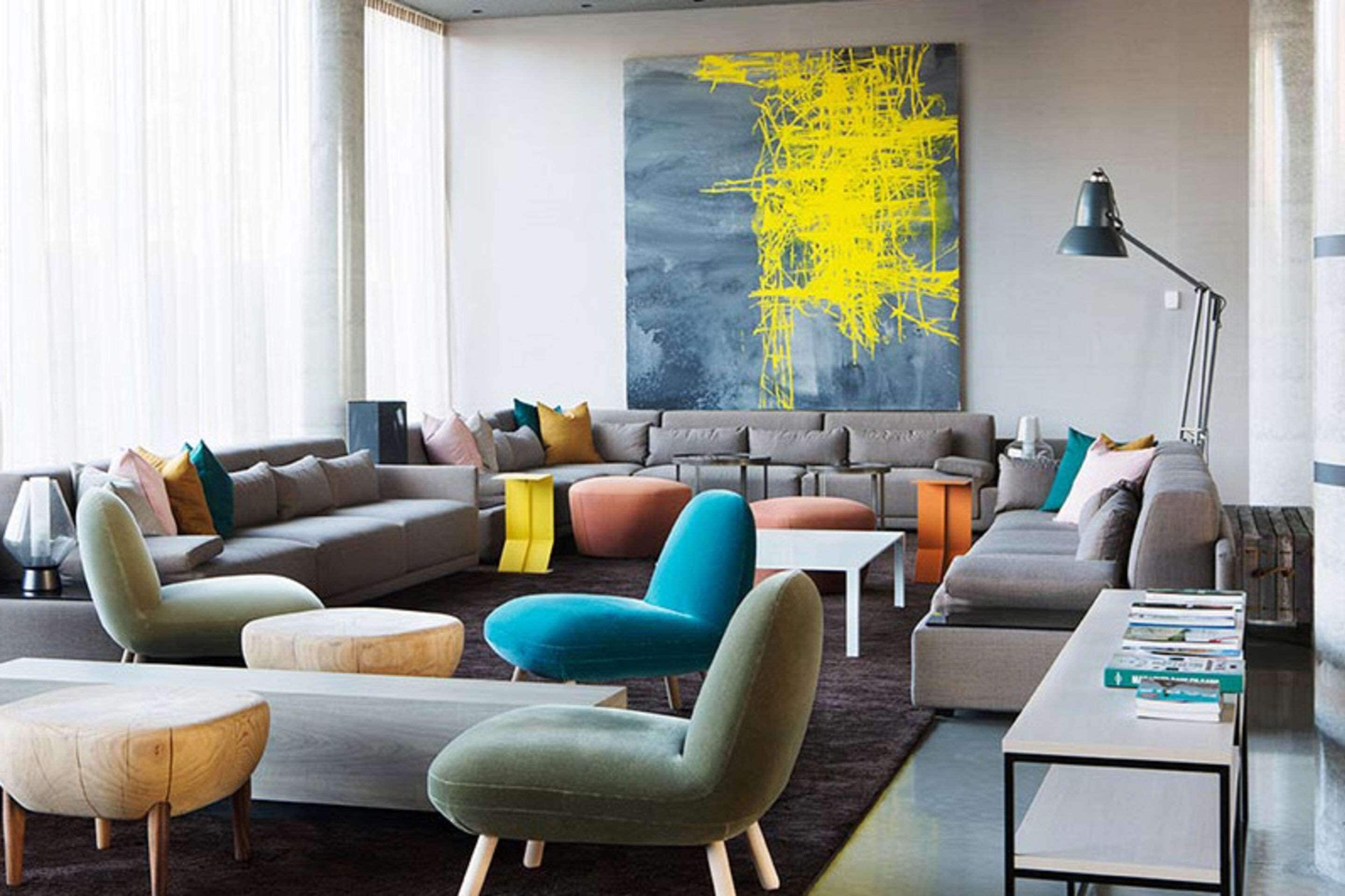 A modern living room with a sectional sofa, a teal armchair, and a coffee table.