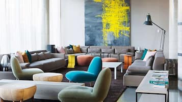A modern living room with a sectional sofa, a teal armchair, and a coffee table.