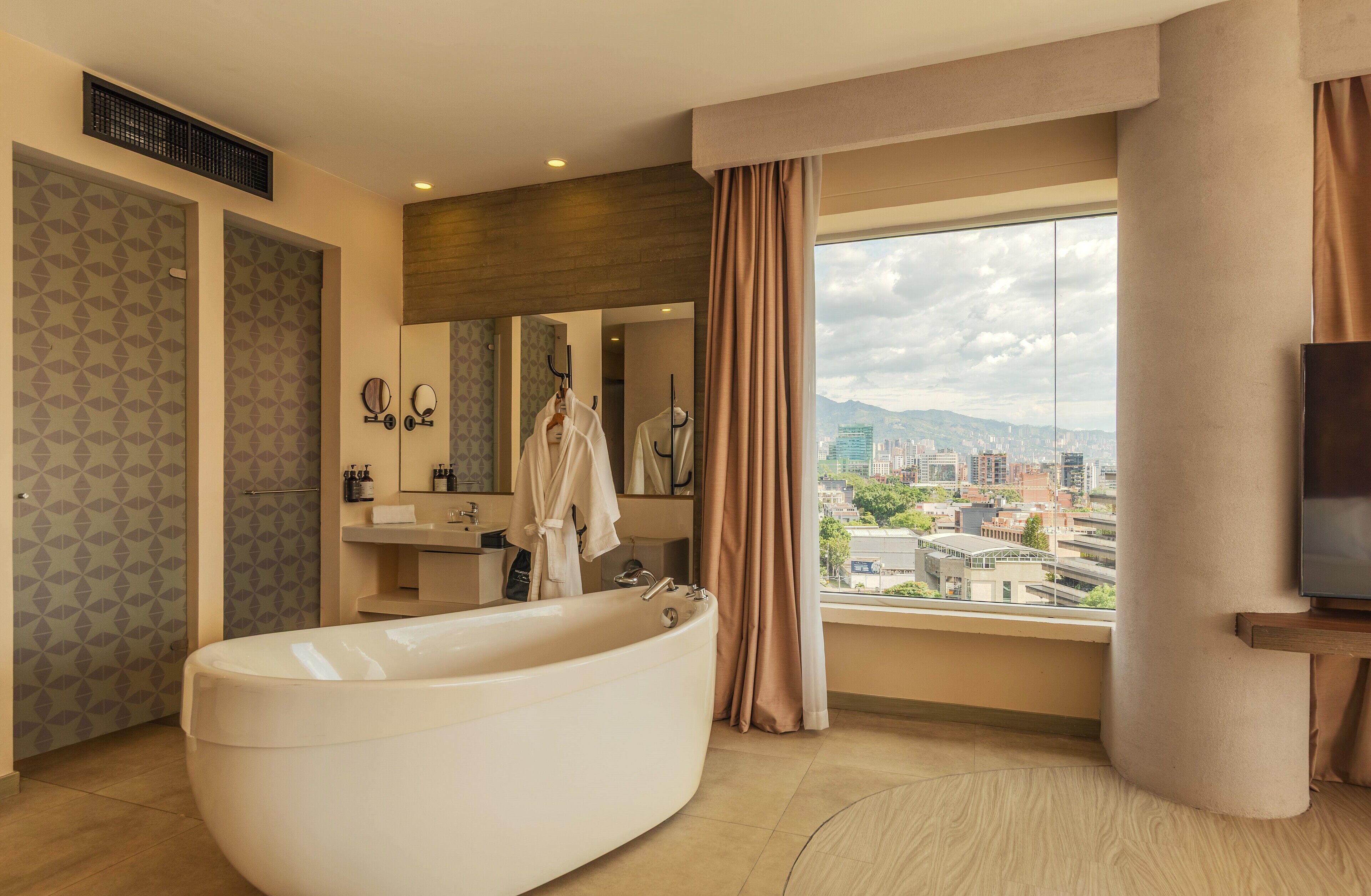 Suite, 1 très grand lit, vue ville | Salle de bain | Douche, douche à « effet pluie », articles de toilette gratuits