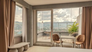 Ein modernes Hotelzimmer mit einem großen Balkon, einem Esstisch und Stühlen.