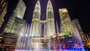 Las Torres Petronas con un espectáculo de fuentes en frente.